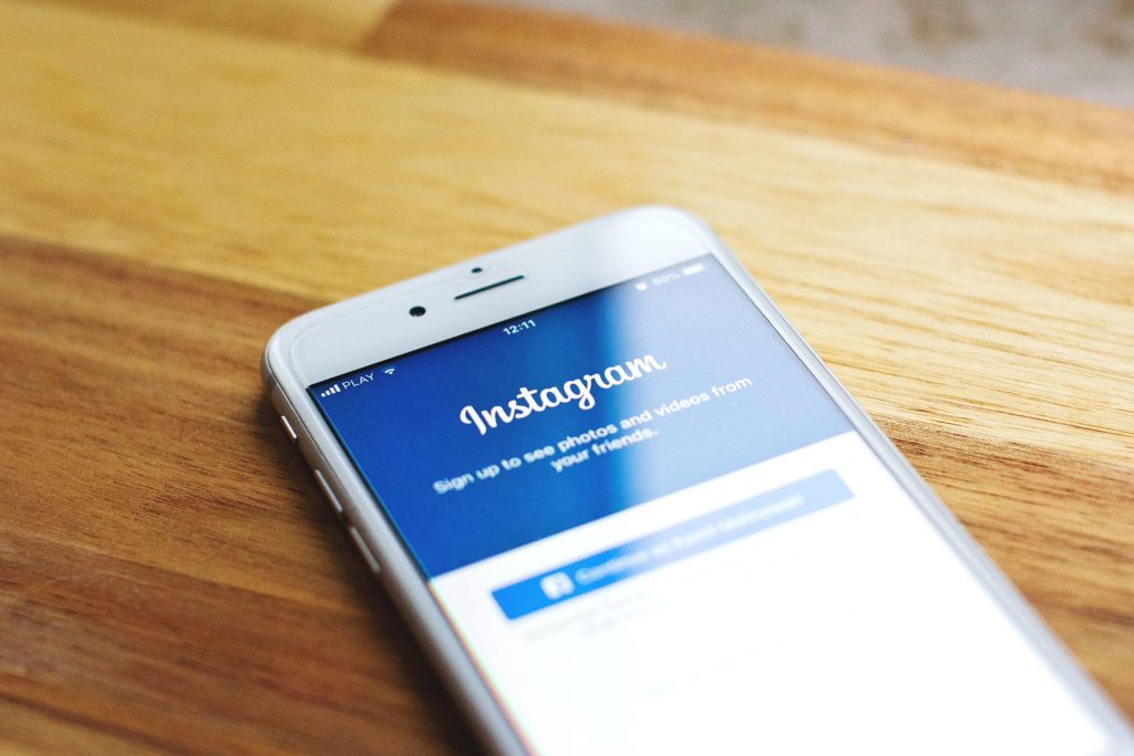 phone on table displaying instagram - SlyFox Web Design and Marketing