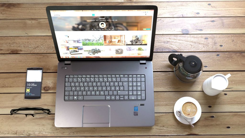 laptop computer with smartphone and coffee beside it - SlyFox Web Design and Marketing